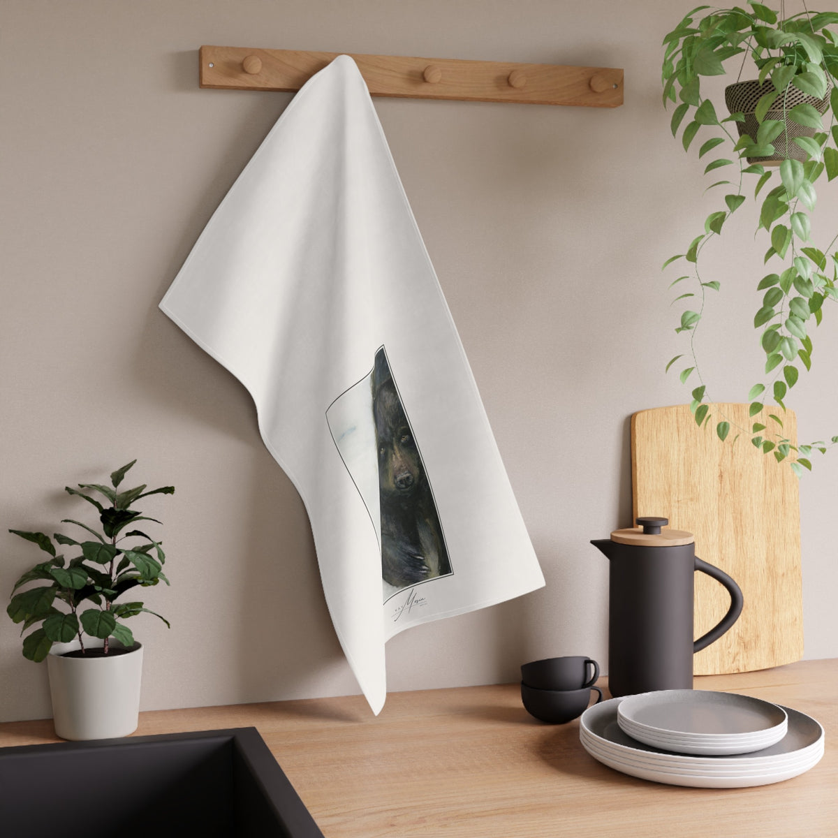 Black Bear tea towel displayed in a kitchen; original artwork by Kay Mesia