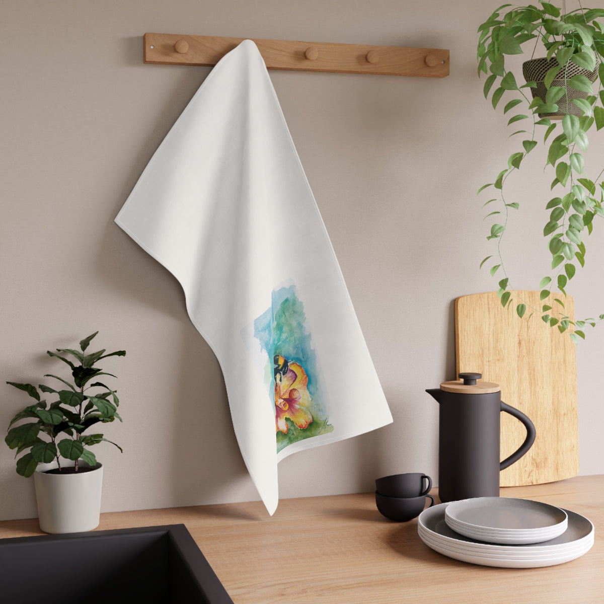 Bee on Yellow Flower tea towel displayed in a kitchen; original artwork by Kay Mesia